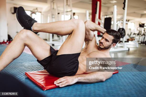 homme faisant des abdos dans la salle de gym - musculation des biceps photos et images de collection