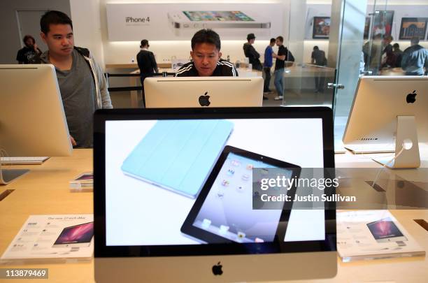 Customer looks at an iMac computer at an Apple Store following an announcement that Apple has become the world's most valuable brand on May 9, 2011...