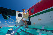 first class trip woman getting out from seaplane on private island