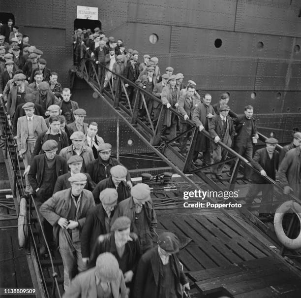 View of workers and employees of John Brown and Company shipbuilders pictured leaving the hull of a ship under construction for a lunch break before...