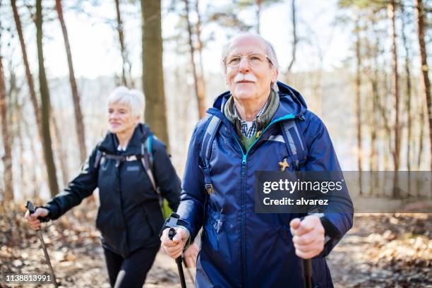 senior man hiking with friend - nordic walking stock pictures, royalty-free photos & images