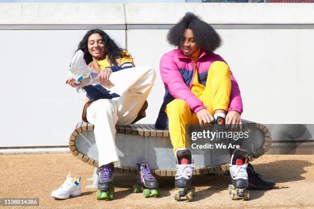 friends putting on rollerskates - couple skating stock pictures, royalty-free photos & images