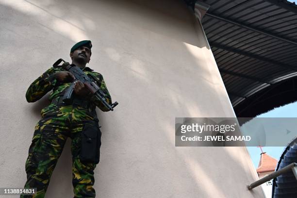 Soldier stands guard during a memorial service for bomb blast victims at St Sebastian's Church in Negombo on April 23 two days after a series of bomb...
