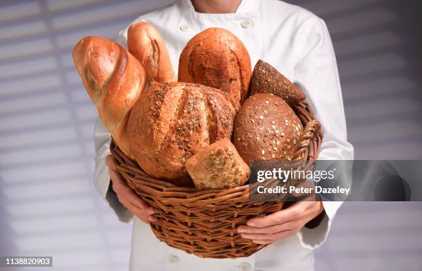 artisanal bread carried by junior baker - basket stock-fotos und bilder