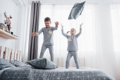 Children in soft warm pajamas playing in bed