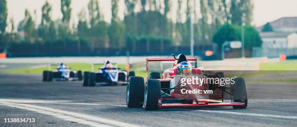 tres coches de carreras de fórmula en la pista de carreras - gran premio de carreras de motor fotografías e imágenes de stock