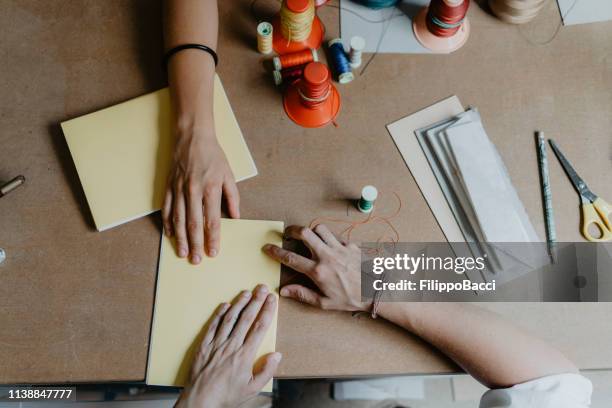 jeune femme adulte faisant un cahier - reliures photos et images de collection