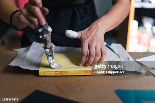 jeune femme adulte faisant un cahier - reliures photos et images de collection