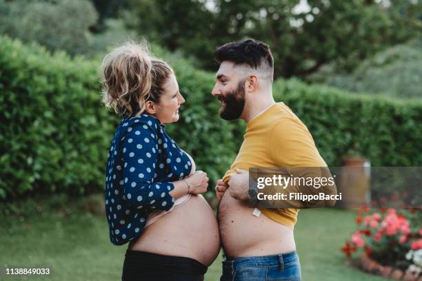 young adult couple in love joking together - stomach child stock pictures, royalty-free photos & images