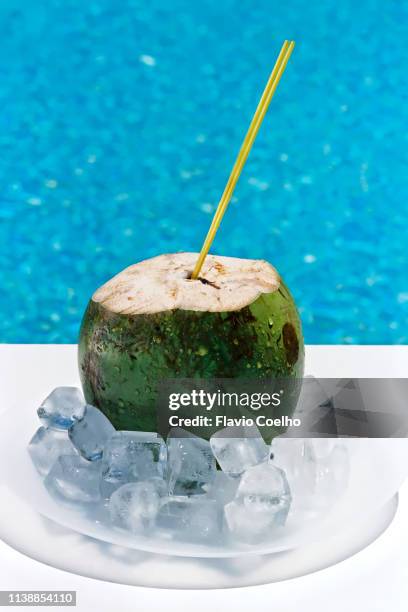 coconut water with ice cubes by the swimming pool - coconut water stock pictures, royalty-free photos & images