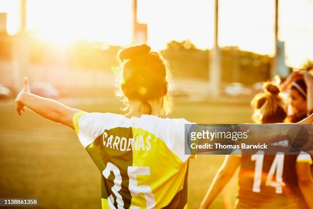Rear view of female soccer player celebrating on field during soccer game