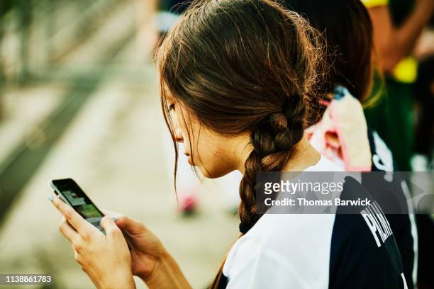 Female soccer player checking smart phone after soccer match