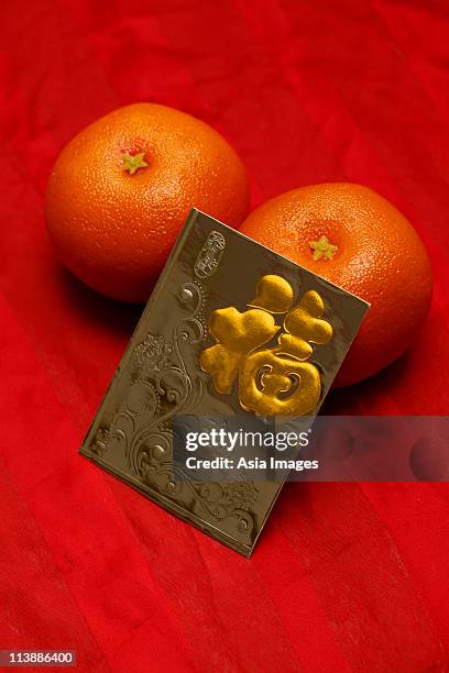 red envelope, hong bao, oranges - chinese new year red envelope stock pictures, royalty-free photos & images