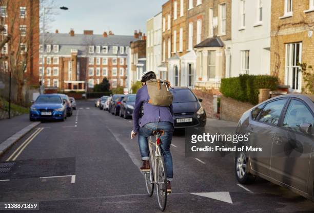 london cycle commuter riding down street in neighborhood on way to work. - bicycle stock pictures, royalty-free photos & images