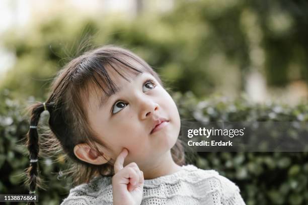 schönes kind spielt thinker mit ernster - cute girl toddler stock-fotos und bilder
