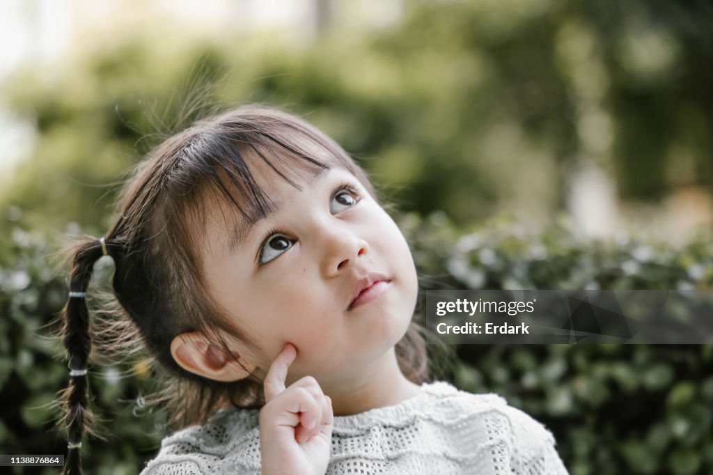 Beautiful kid playing Thinker with serious