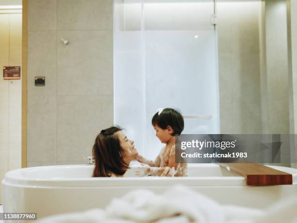 asian mother and baby son having fun at bath time together - kid bath mother stock pictures, royalty-free photos & images