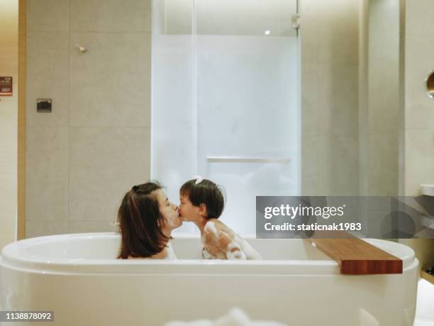 asiatische mutter und baby-sohn haben spaß an der zeit gemeinsam - kid bath mother stock-fotos und bilder