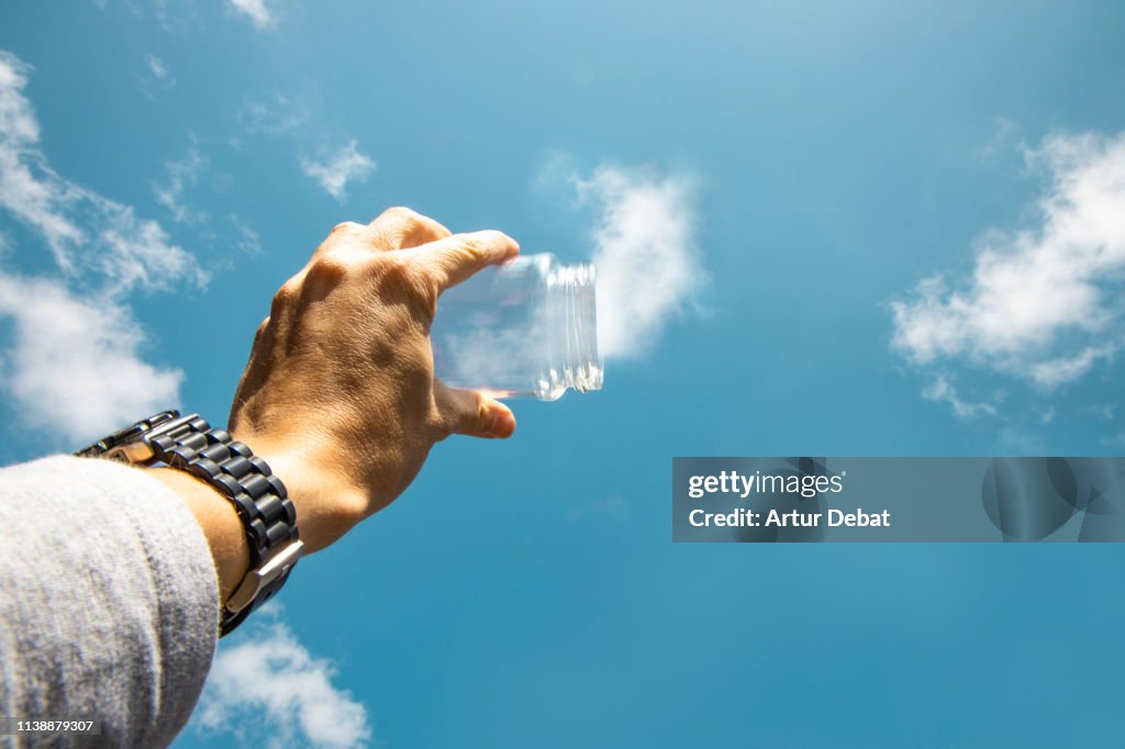 Capturing the clouds from the sky with with glass pot in creative picture from personal perspective.