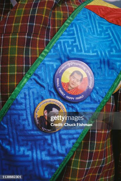 Bhutanese man wearing buttons with pictures of King Jigme Singye Wangchuck, Punakha, Bhutan, 2004.