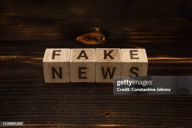 fake news words on wooden blocks - broma pesada fotografías e imágenes de stock