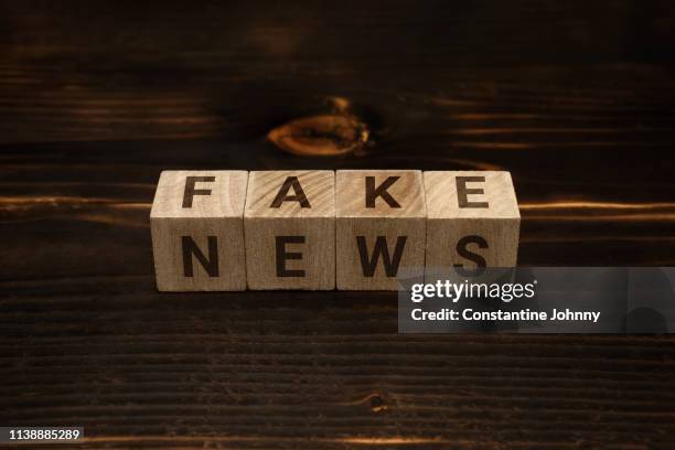 fake news words on wooden blocks - fake advertisement stock pictures, royalty-free photos & images