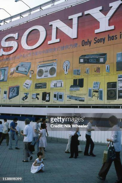 Giant billboard advertising Sony electronic products dwarfs pedestrians on Beijing city street circa 1984;m
