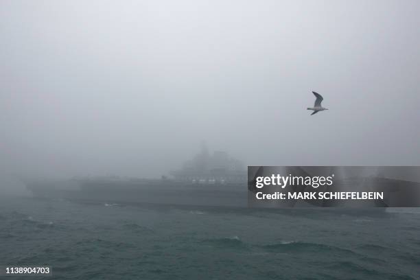 The Chinese People's Liberation Army Navy aircraft carrier Liaoning participates in a naval parade to commemorate the 70th anniversary of the...