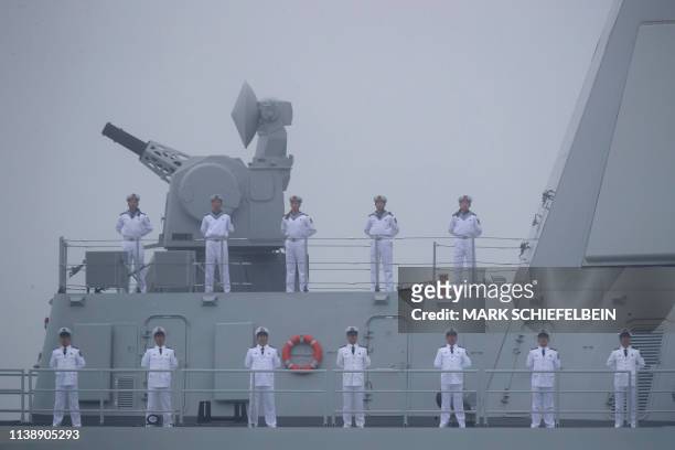 Sailors stand on the deck of the new type 055 guide missile destroyer Nanchang of the Chinese People's Liberation Army Navy as it participates in a...