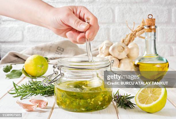 fresh salad dressing with rosemary, garlic and lemon - slasaus stockfoto's en -beelden