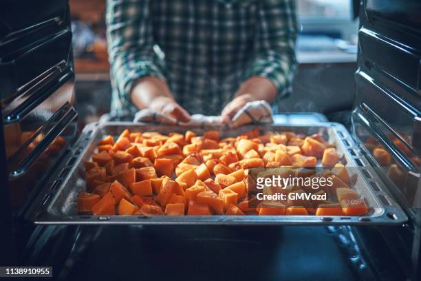 cutting fresh pumpkins for roasting in the oven - hokaido pumpkin stock pictures, royalty-free photos & images