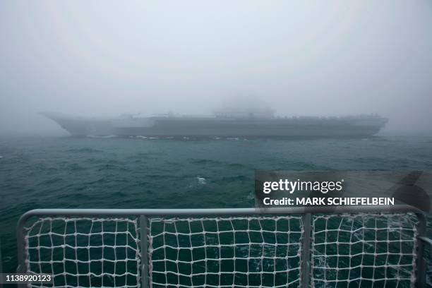 The Chinese People's Liberation Army Navy aircraft carrier Liaoning participates in a naval parade to commemorate the 70th anniversary of the...