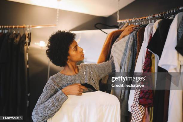 jonge vrouw kiezen wat te dragen vandaag - clothes wardrobe stockfoto's en -beelden