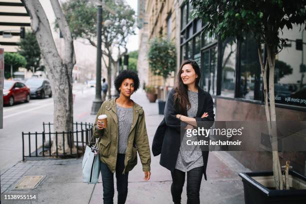 junge freundinnen spazieren in los angeles innenstadt - downtown los angeles stock-fotos und bilder