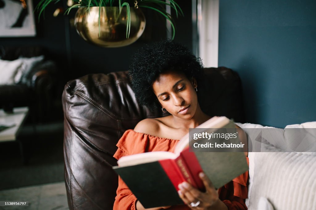 一個年輕女子在洛杉磯市中心的公寓裡放鬆和閱讀的肖像
