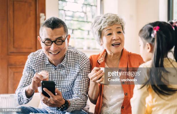 happy childhood with grandparent - hong kong grandmother stock pictures, royalty-free photos & images