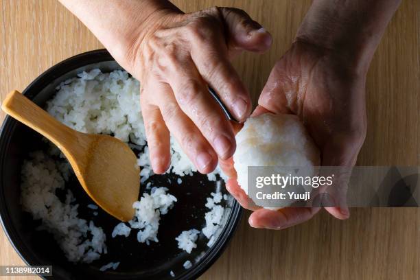 japanese senior woman holding rice ball and cooked rice - rice ball stock pictures, royalty-free photos & images