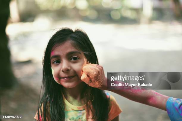 Portrait of a young girl playing Holi