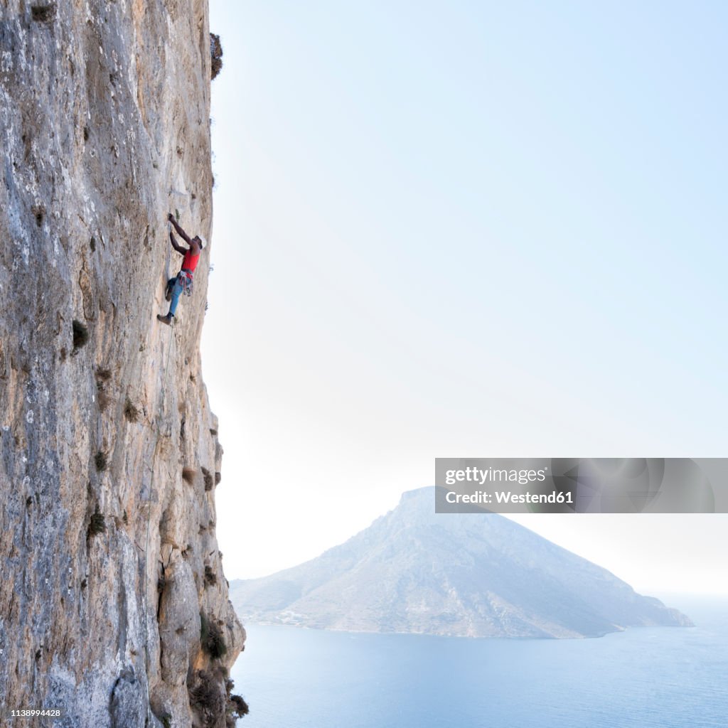 Greece, Kalymnos, climber in rock wall above the sea