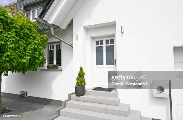 germany, cologne, entrance of white new built one-family house - man at front door stock-fotos und bilder