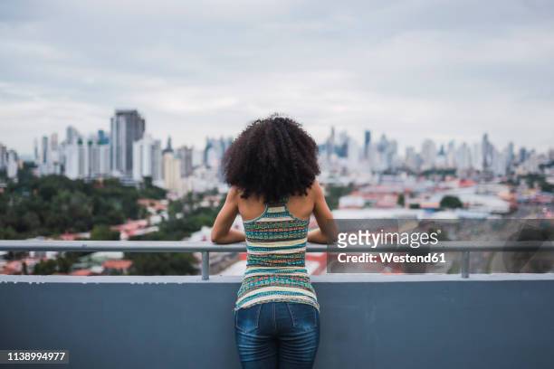 panama, panama city, back view of  young woman standing on balcony looking at view - panama city panama 個照片及圖片檔