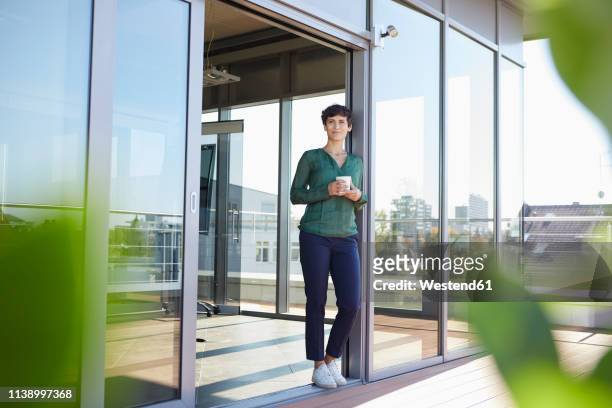smiling woman standing at the window having a coffee break - coffee on patio stock pictures, royalty-free photos & images