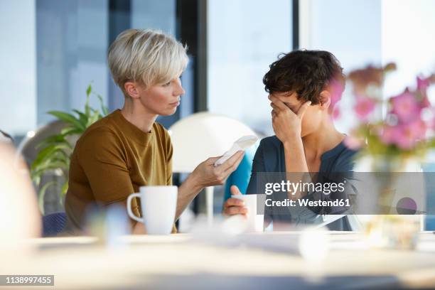 woman consoling crying friend - handkerchief stock pictures, royalty-free photos & images