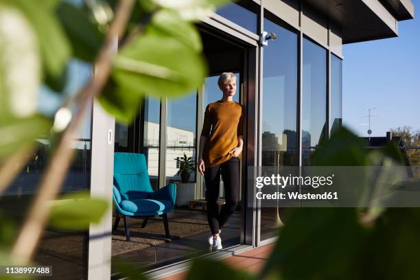 woman standing at the window on roof terrace - balcony window stock pictures, royalty-free photos & images