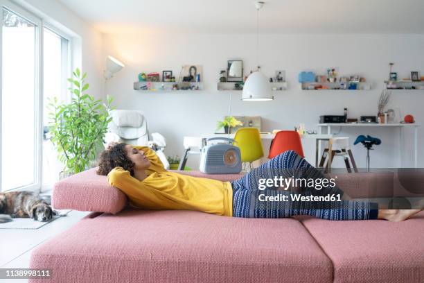 woman lying on couch at home relaxing - portable radio stock pictures, royalty-free photos & images