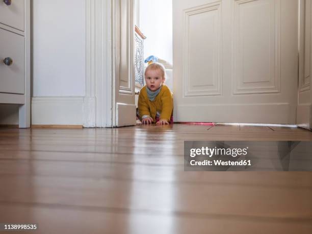 portrait of baby girl exploring apartment - door ajar stock pictures, royalty-free photos & images