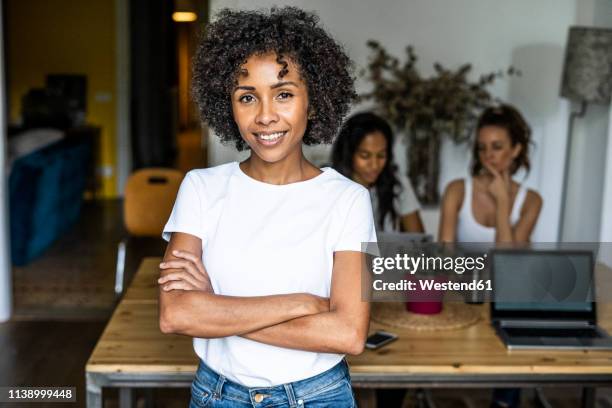 portrait of smiling woman at home with friends in background - black woman happy white background foto e immagini stock