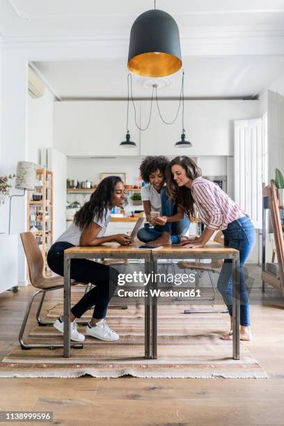 three happy women with digital devices on table at home - friend at work photos et images de collection