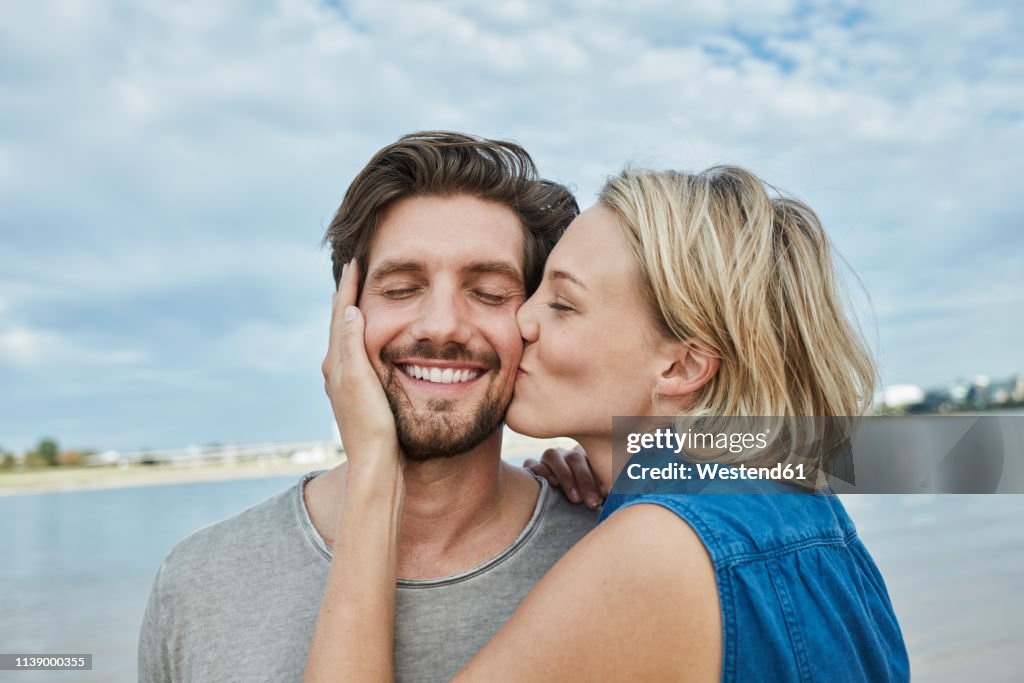 Happy young couple kissing on the beach