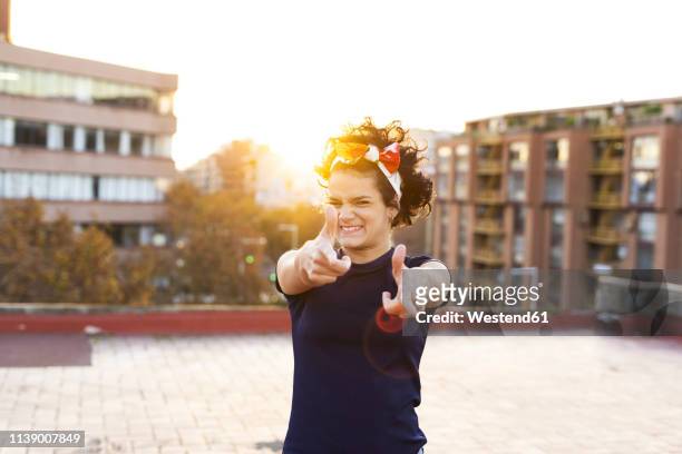 portrait of young woman having fun in the city at sunset - alzar los brazos fotografías e imágenes de stock